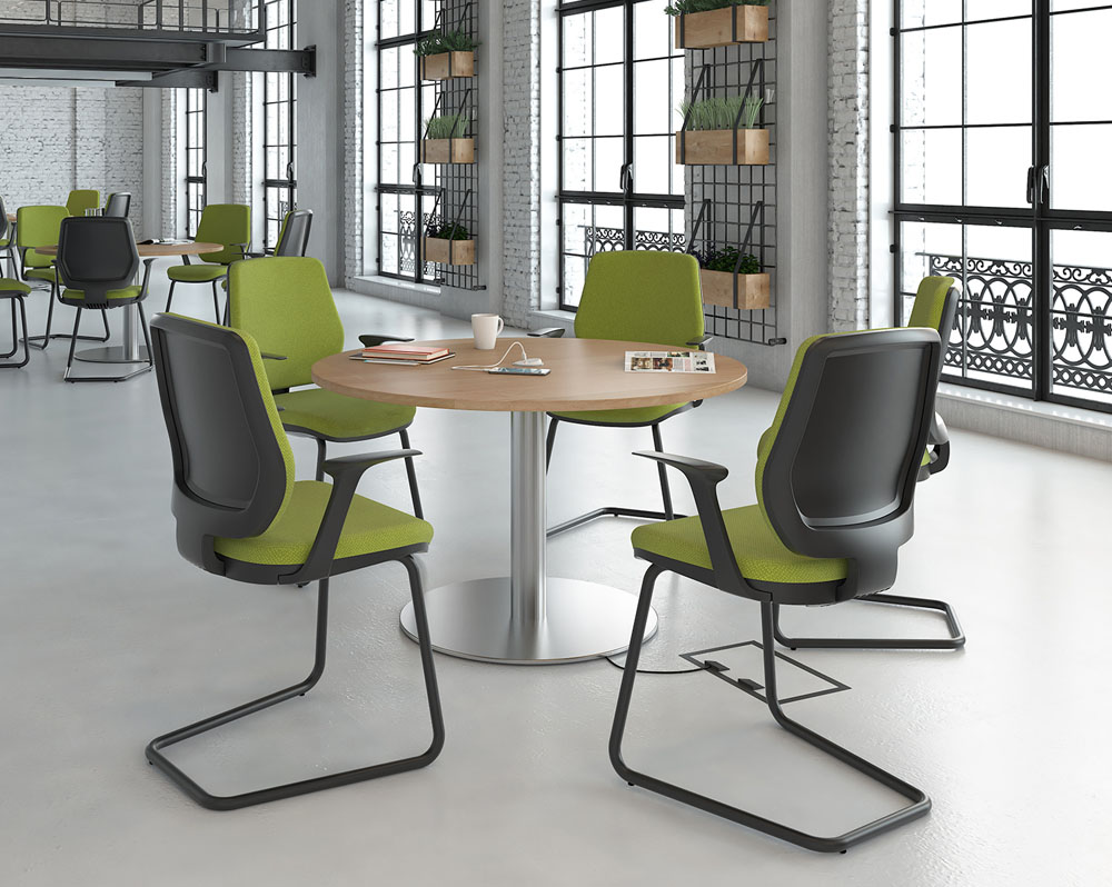 Breakout chairs with a black cantilever frame and green fabric seat
