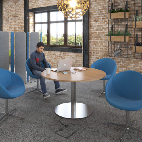 Fabric breakout chairs around a circular meeting table
