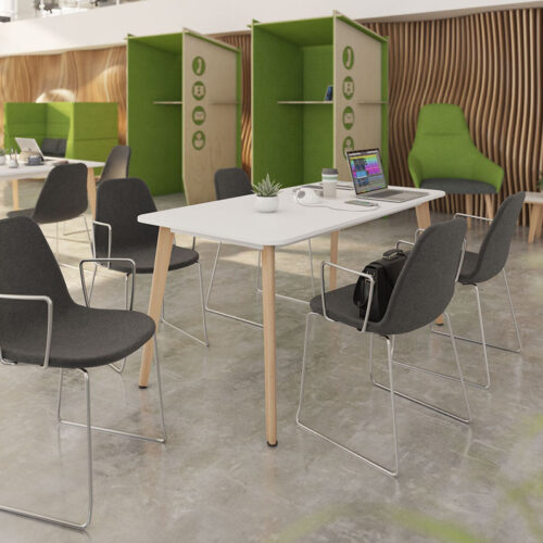 Café and bistro chairs with chrome sled frame and grey fabric seat. Around a rectangular dining table, with white top and wooden legs
