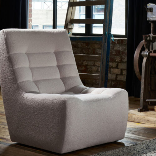 Luxurious lounge chair in cream fabric on a wooden floor