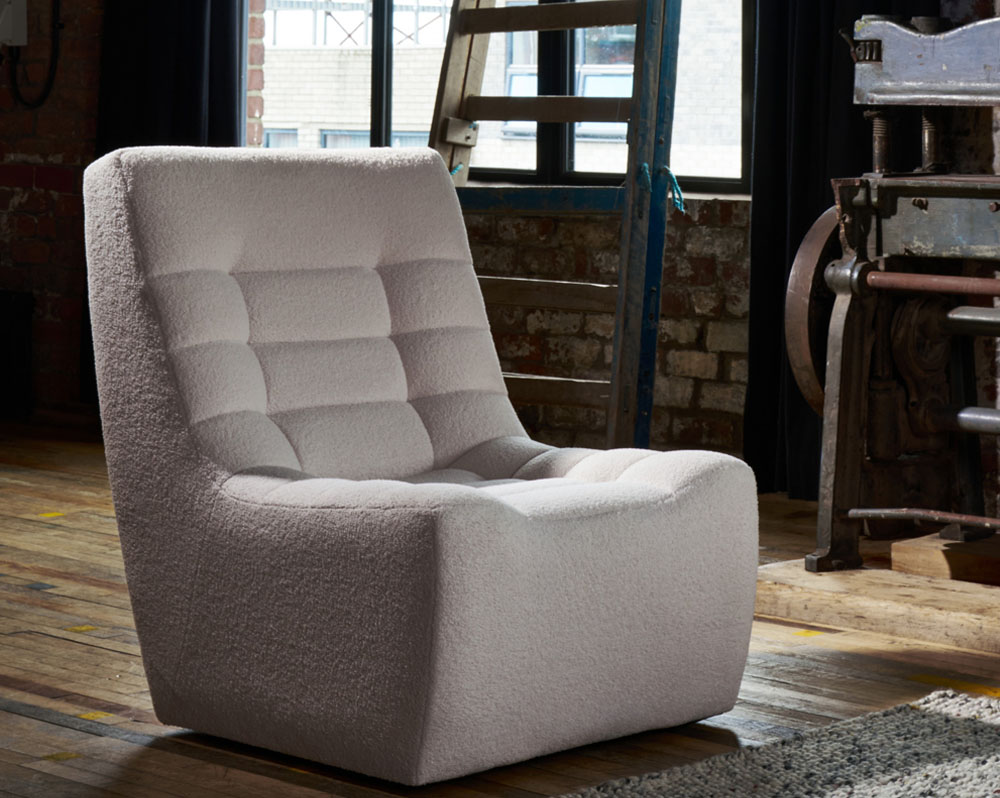 Luxurious lounge chair in cream fabric on a wooden floor