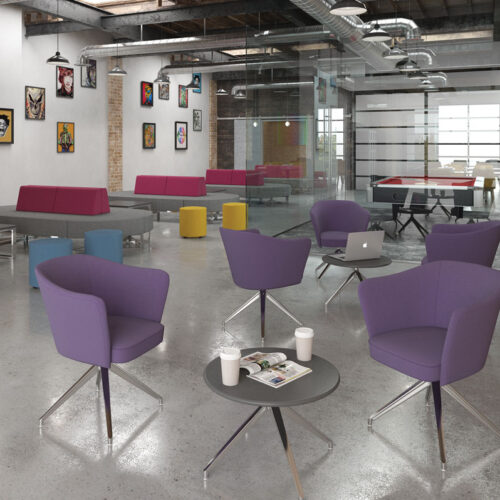 Lounge chairs in purple fabric and a pyramid steel base around a circular coffee table