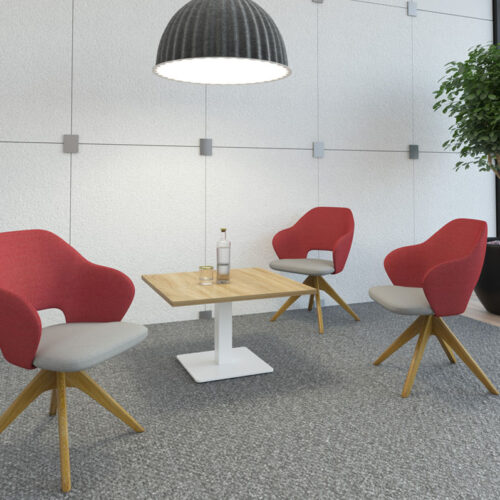 Three lounge chairs in red and grey fabric and a pyramid wooden base around a small square coffee table with oak top