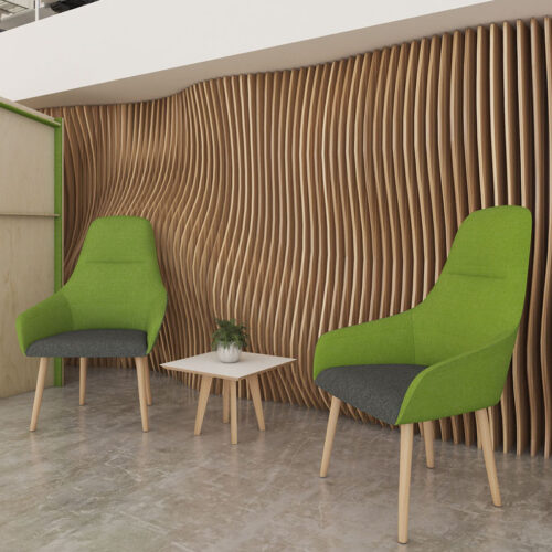 Two green and grey fabric lounge chairs and a small square coffee table in a social space