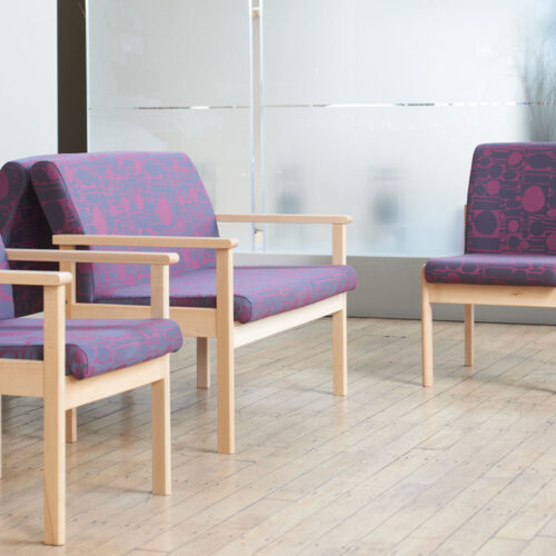 Waiting room chairs in purple fabric and with a wooden frame, in a medical practice waiting room