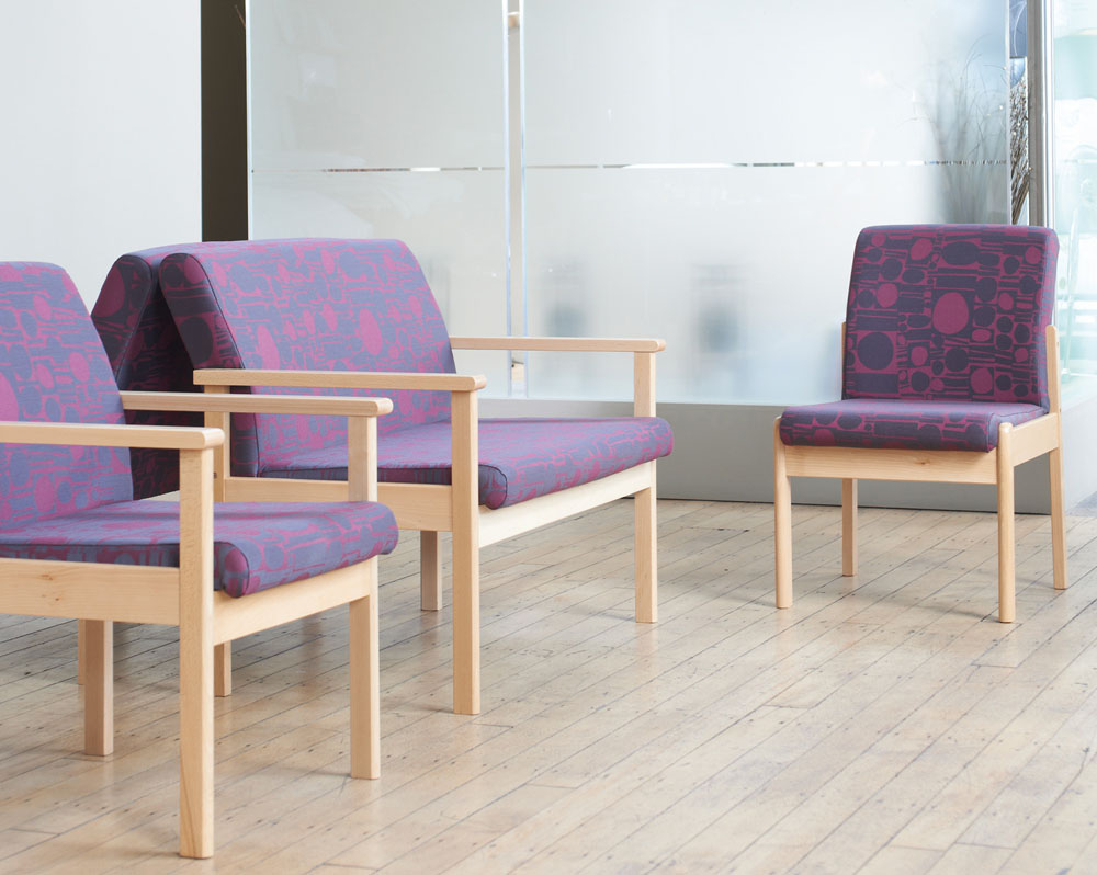 Waiting room chairs in purple fabric and with a wooden frame, in a medical practice waiting room