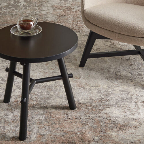 Small round Aria coffee table with a cup of coffee on top of it