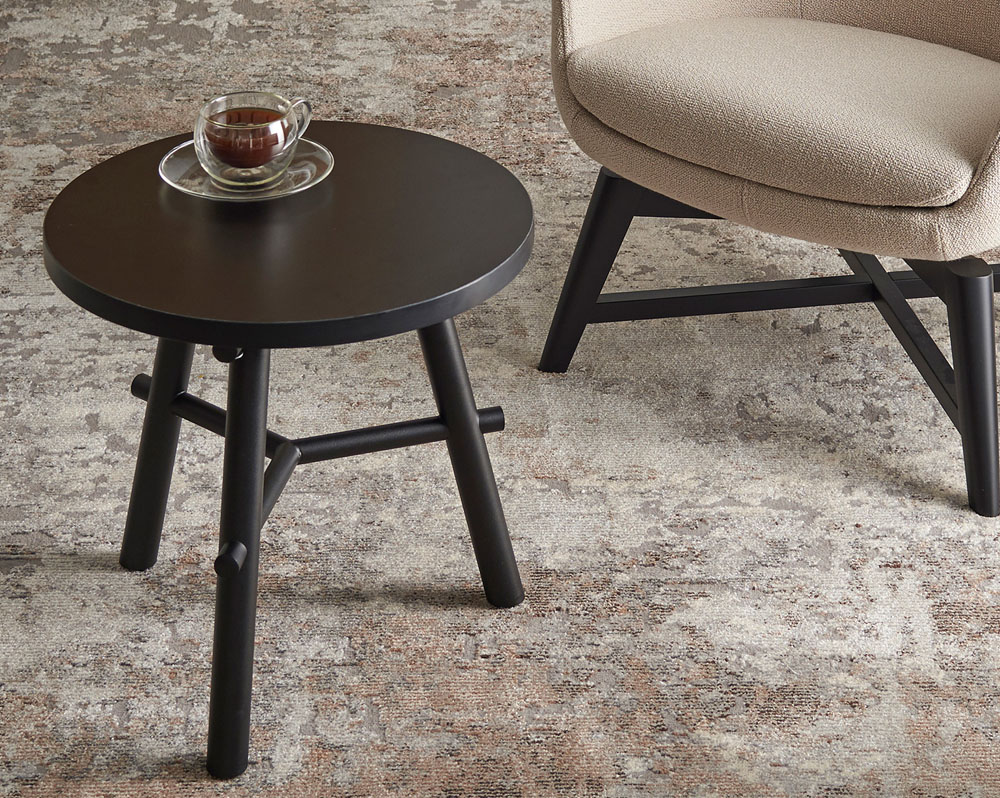 Small round Aria coffee table with a cup of coffee on top of it