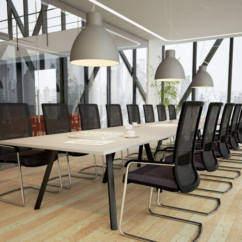A large boardroom table with black cantilever chairs around it.