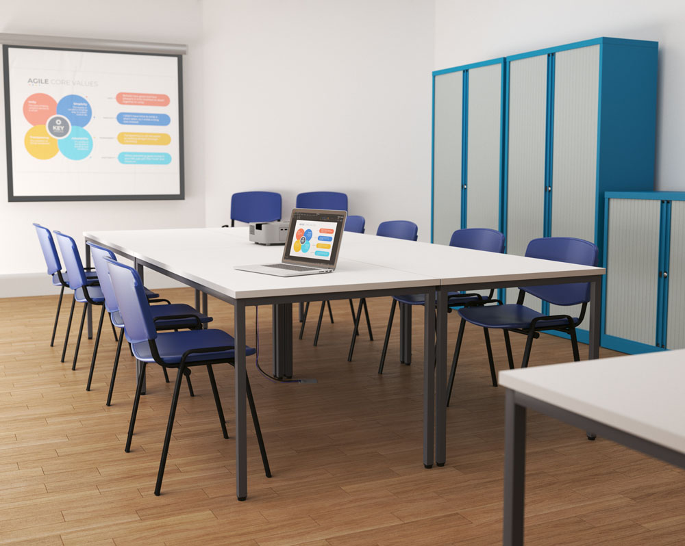 4 rectangular education tables, with blue chairs, in a school classroom