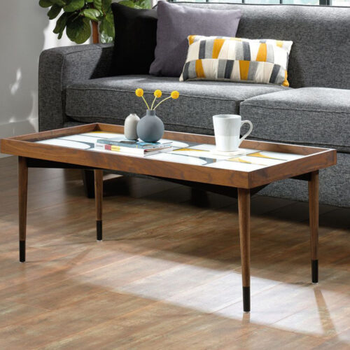 A rectangular coffee table with screen printed top in front of a grey sofa