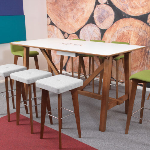 A wooden framed table and stools in a an open plan office