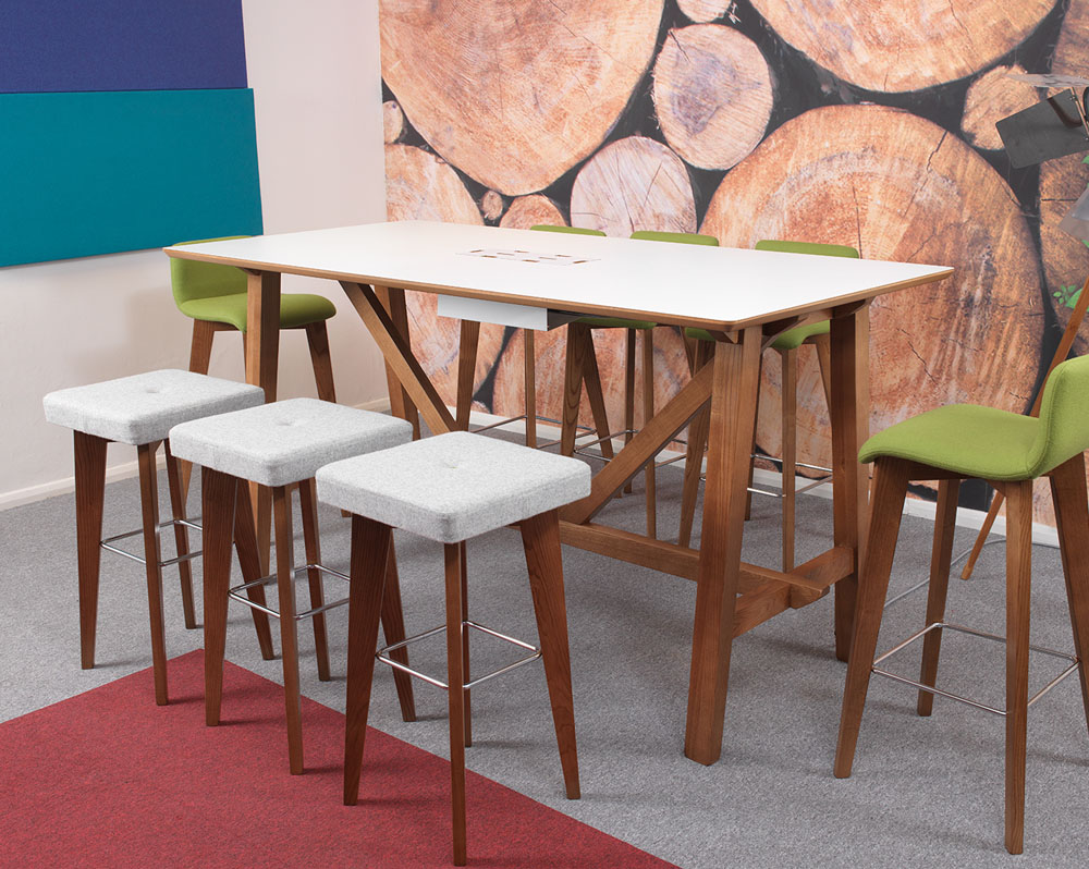 A wooden framed table and stools in a an open plan office